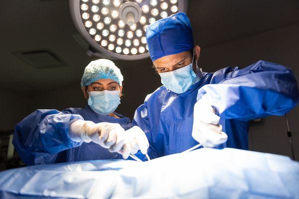 Surgical team performing vasectomy on patient